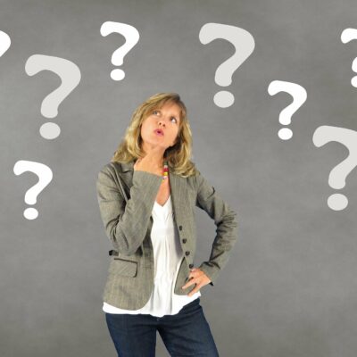 Prenotare un accompagnatore – Una donna guarda un punto interrogativo su uno sfondo grigio