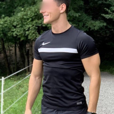 Attraktives Männermodell in dunklem T-Shirt im Wald