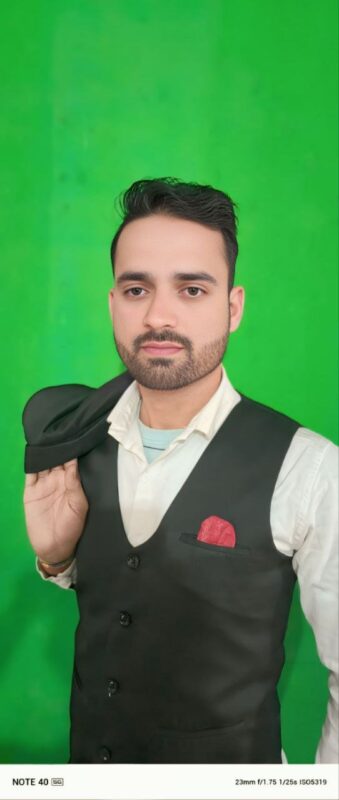 The scene you described sounds like a classic and stylish portrait. The mans attire, with the white shirt and black vest, suggests a timeless and formal look. The black hat being held over his shoulder adds an element of sophistication, while the red pocket square provides a pop of color that enhances the overall visual appeal. The green background could complement the outfit by providing a nice contrast with both warm and cool tones, creating an interesting visual balance in the image. This setup could work well for various contexts such as fashion photography, formal events promotions, or character introductions in creative projects.