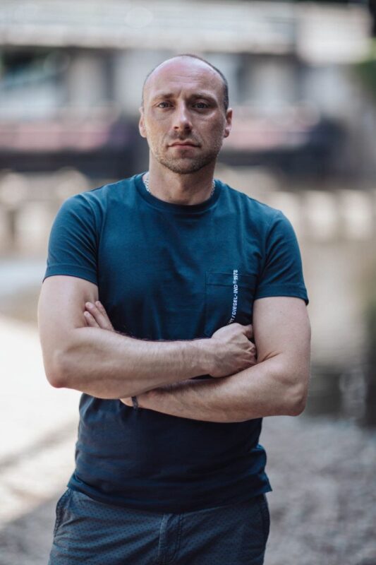 Es hört sich an, als würden Sie ein Foto eines Mannes namens Callboy Carlo beschreiben. Er ist mit rasiertem Kopf und Bart abgebildet, trägt ein blaues T-Shirt und Shorts und steht im Freien. Seine Arme sind vor der Brust verschränkt, und sein Gesichtsausdruck ist ernst, während er direkt in die Kamera blickt. Der Hintergrund ist unscharf, was Tiefe erzeugt und die Aufmerksamkeit auf Carlo als zentrales Motiv lenkt. Falls Sie diese Beschreibung verfeinern möchten (beispielsweise für soziale Medien, einen Artikel oder die Erstellung von Kunstwerken), hier eine verbesserte Version: --- Ein bärtiger Mann mit rasiertem Kopf steht selbstbewusst im Freien, die Arme vor der Brust verschränkt. Lässig in ein blaues T-Shirt und Shorts gekleidet, blickt er ernst in die Kamera. Der unscharfe Hintergrund rückt ihn – Callboy Carlo – scharf in den Fokus und betont seine starke Präsenz. --- Lassen Sie mich wissen, wenn Sie weitere Anpassungen wünschen!.